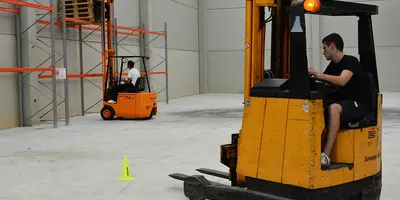 Ein junger Mann übt das Fahren mit einem Gabelstapler