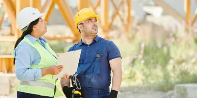 Zwei Menschen stehen zusammen auf einer Baustelle