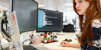 Frau in Bluse sitzt vor dem Computer